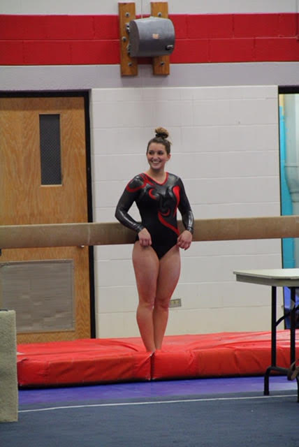 Senior Taylor Shanahan poses in front of the beam before beginning her routine. Shanahan is the captain of the girls gymnastics team.