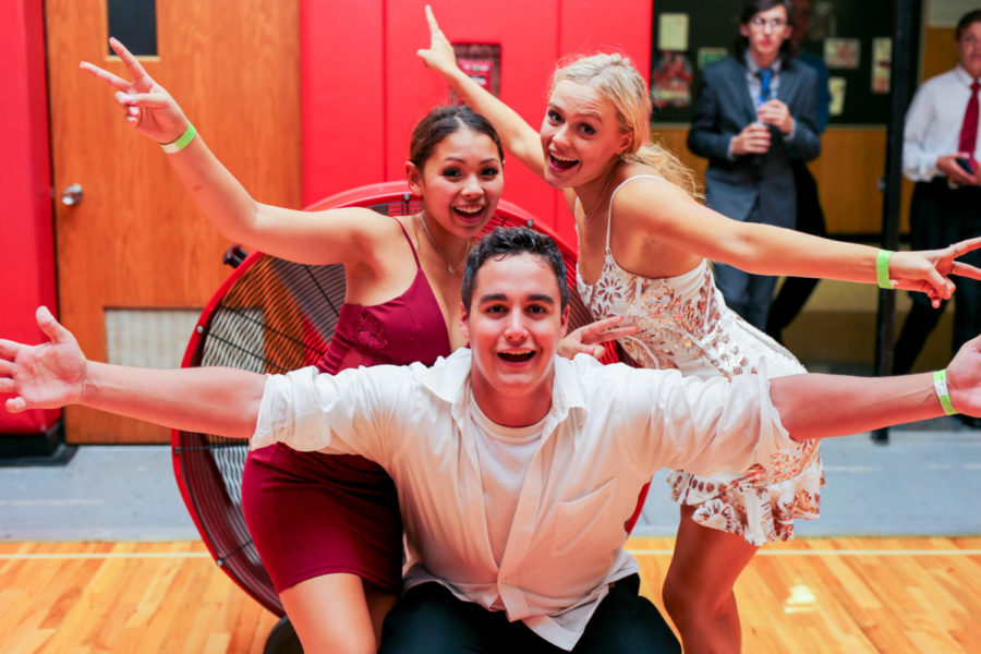 Seniors Jessica Nayden, Sarah Parduhn and Anthony Heelan pose in front of a fan after taking a break from dancing at this year’s homecoming dance. 