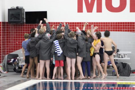 The boys swim & dive team huddles up for a traditional cheer before the start of Senior Night at a home meet against Warren Township High School on Thursday, Jan. 20.