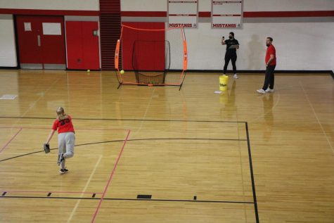 At the first day of tryouts on Monday, Feb. 28, Junior Makenna Wolf throws a softball at a net as Junior Varsity II Coach Wendy Inman tracks the velocity of her throw.
