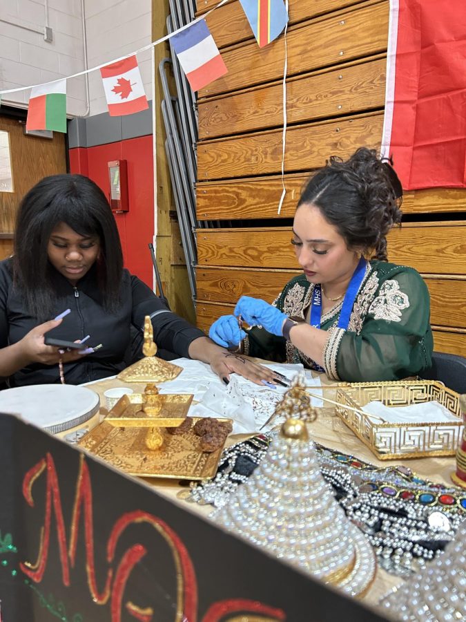 An artist’s hand: Sahara Ivie Abdul-Haqq, sophomore gets henna done on her hand by Hala Fakhoury at the Moroccan booth at the Cultural Fair. Many Moroccans see henna as a symbol of good luck.