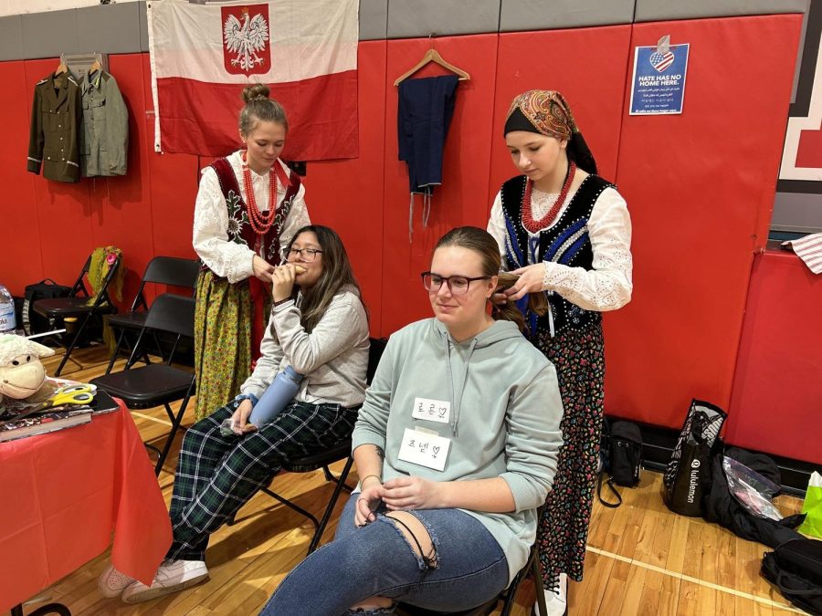 Braiding hair, beautiful heritage: Students get their hair braided at the Polish booth by Senior Alicia Brak and Freshman Leila Vickerman.