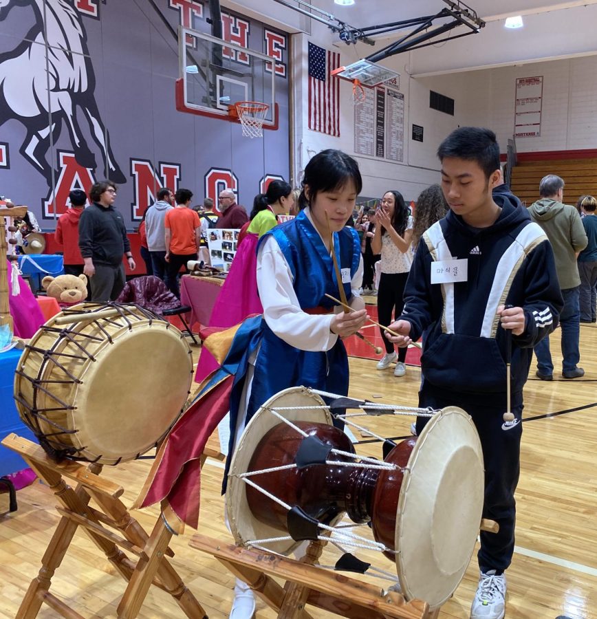 Sharing cultural celebrations: Senior Faith Cho at the Korea booth teaching MHS students how to play Korean drums. Hundreds of years ago, Korean farmers would play these drums to celebrate and give thanks for a good harvest. Cho had been learning how to play these drums for seven years, and wanted to share the music with others. “My culture is super important to me,” said Cho. “It makes me who I am. I used to reject it but I realized that I like myself better when I embrace it. I am no longer ashamed of it, but proud to be who I am.”
