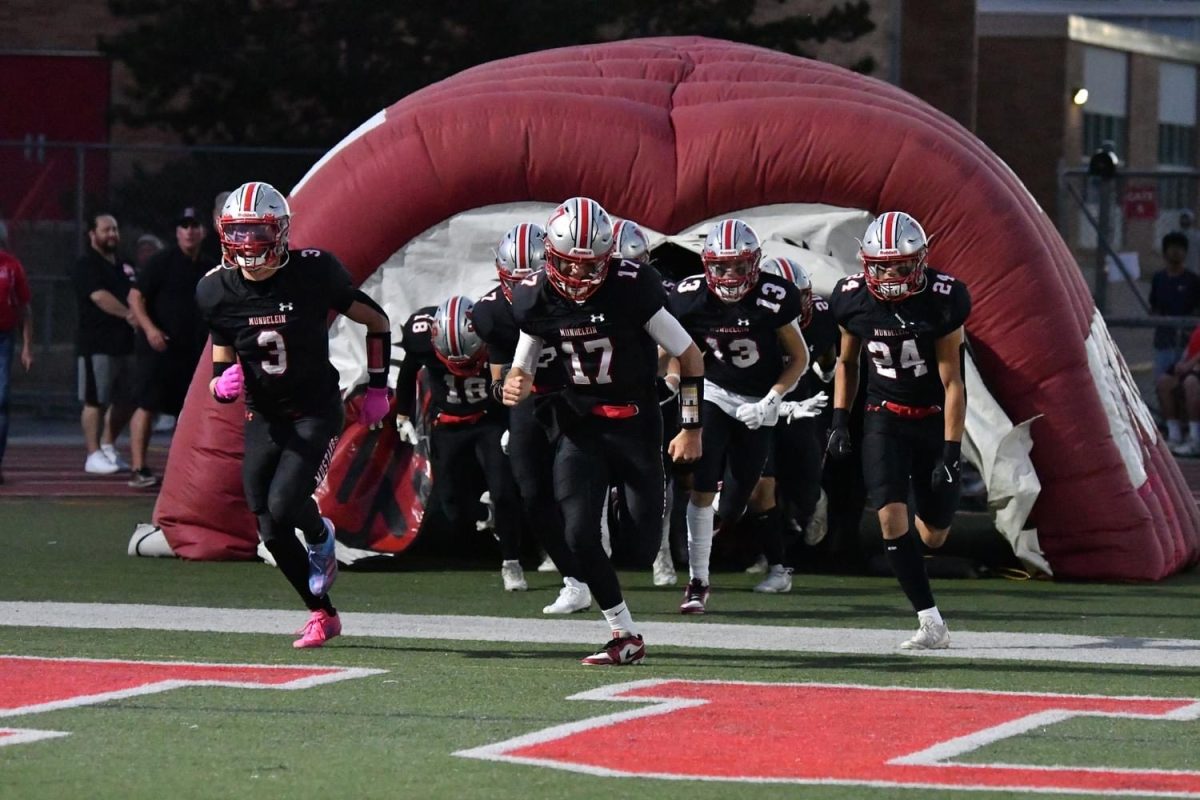 Mundelein Varsity football team runs out of the tunnel before the game on  Community Night, vs. Stevenson High School football game. 