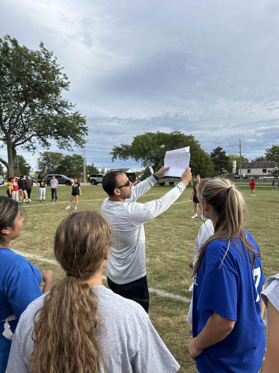 Coach Vince DeFrancesco runs through flag football plays with the junior class during a practice which brought them to their win.